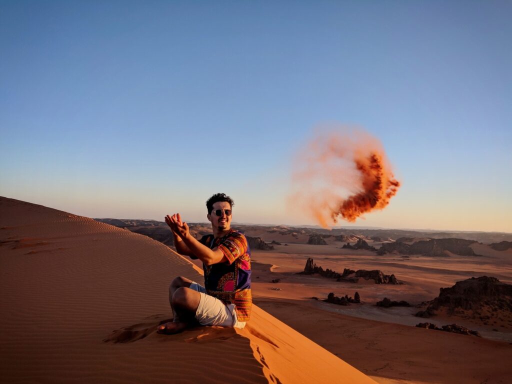 full-length-man-throwing-sand-while-sitting-sand-dune